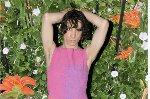 Noa Micaela Fields in a pink top by Mariposa Divina, in front of a lush verdant background.